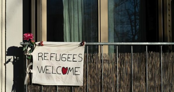 Balkong med skylt, refugees welcome.